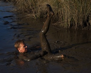 man covered in swamp mud