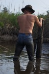 man in tight, wet jeans, standing knee deep in water