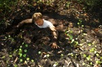 man nearly immersed in thick, swamp mud