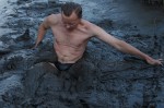 man, sinking into swamp mud, waist deep, black briefs