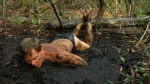 man in latex briefs, tied up in the swamp mud
